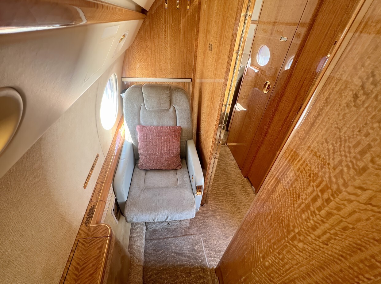The forward crew rest area of this 2010 Gulfstream G550 provides a private and comfortable space for flight crew members. Featuring a reclining leather seat, soft lighting, and window access, it offers a quiet retreat designed for rest during long-range operations, maintaining both comfort and efficiency on extended flights.