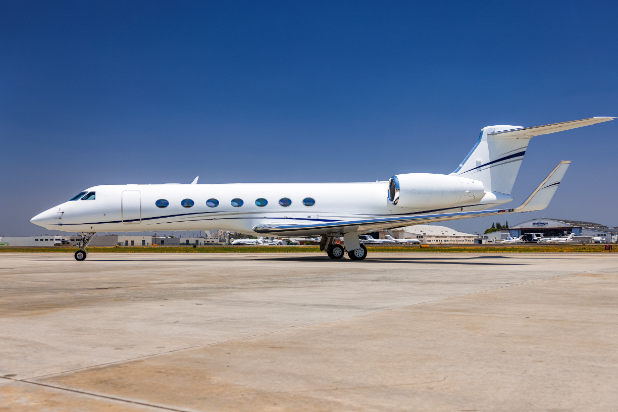 2016 Gulfstream G550, sleek white private jet with distinctive Gulfstream design, parked on runway.