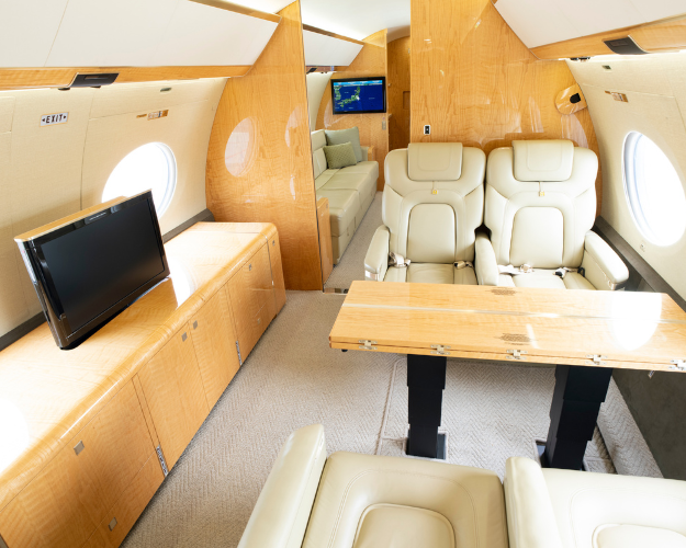 Functional mid cabin of the 2014 Gulfstream G650ER with a four-place conference group opposite a credenza for productive meetings or socializing.