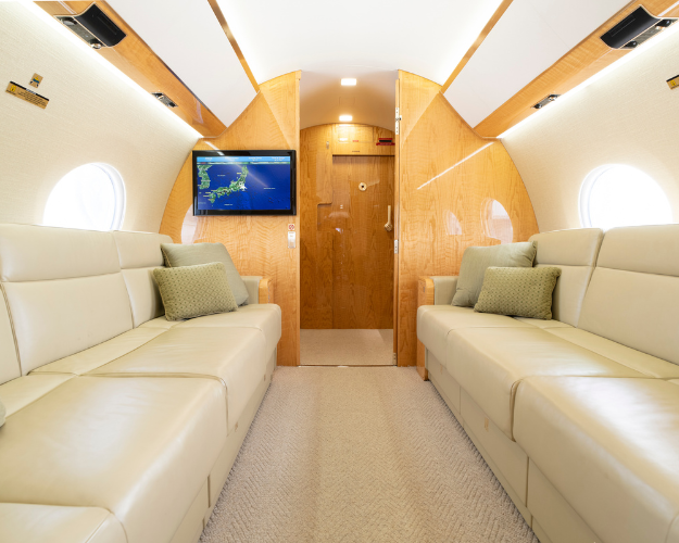 Luxurious aft cabin of the 2014 Gulfstream G650ER featuring two three-place berthing divans for comfort and relaxation during long flights.