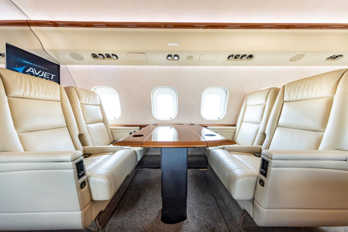 Side view of the mid cabin in a 2006 Bombardier Global XRS jet, featuring a table with four chairs.