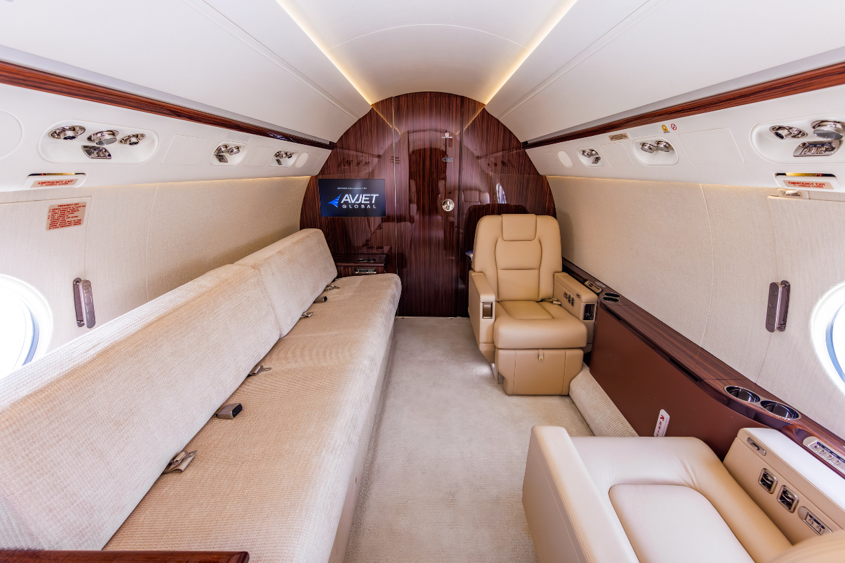 Aft cabin view of the Gulfstream G550, featuring left two-place club seating opposite a single berthing four-place divan.