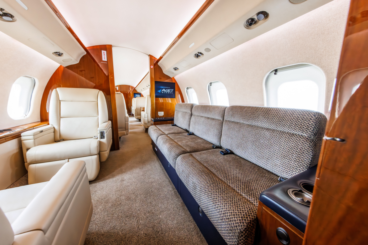 Front facing view of aft cabin in 2006 Bombardier Global XRS, showing a couch across from two chairs.