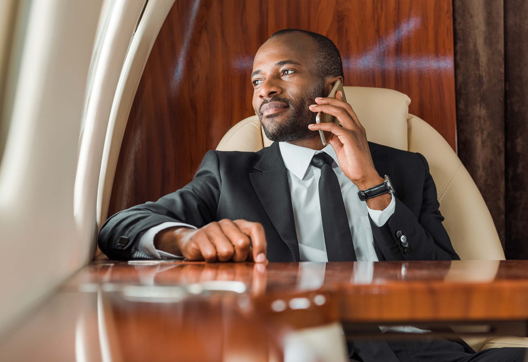 Businessman on the phone inside a private jet