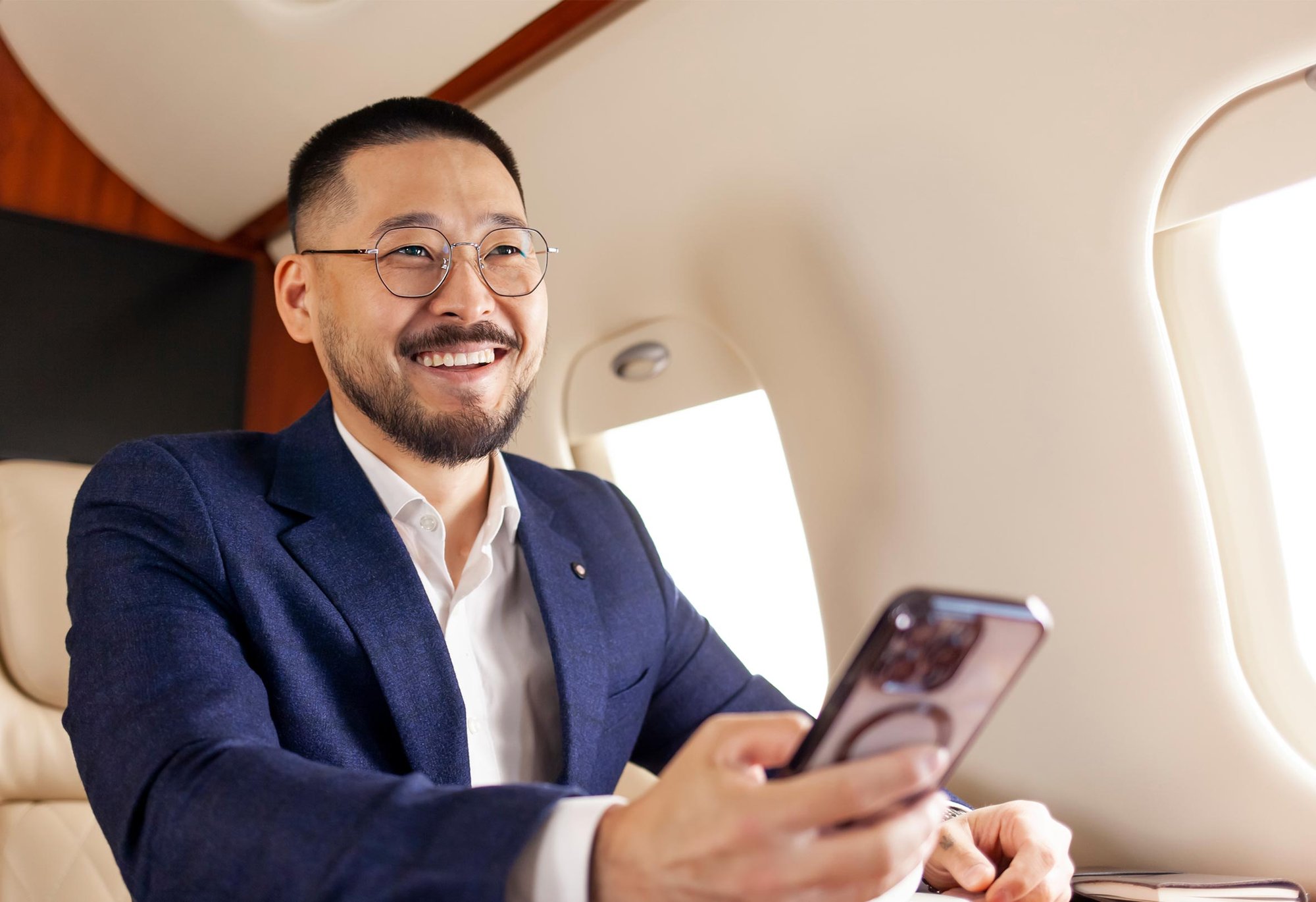 A Businessman using his phone on a private jet