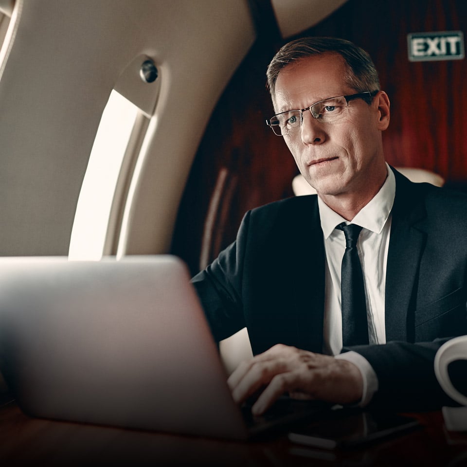 A business person using a laptop while in a private jet