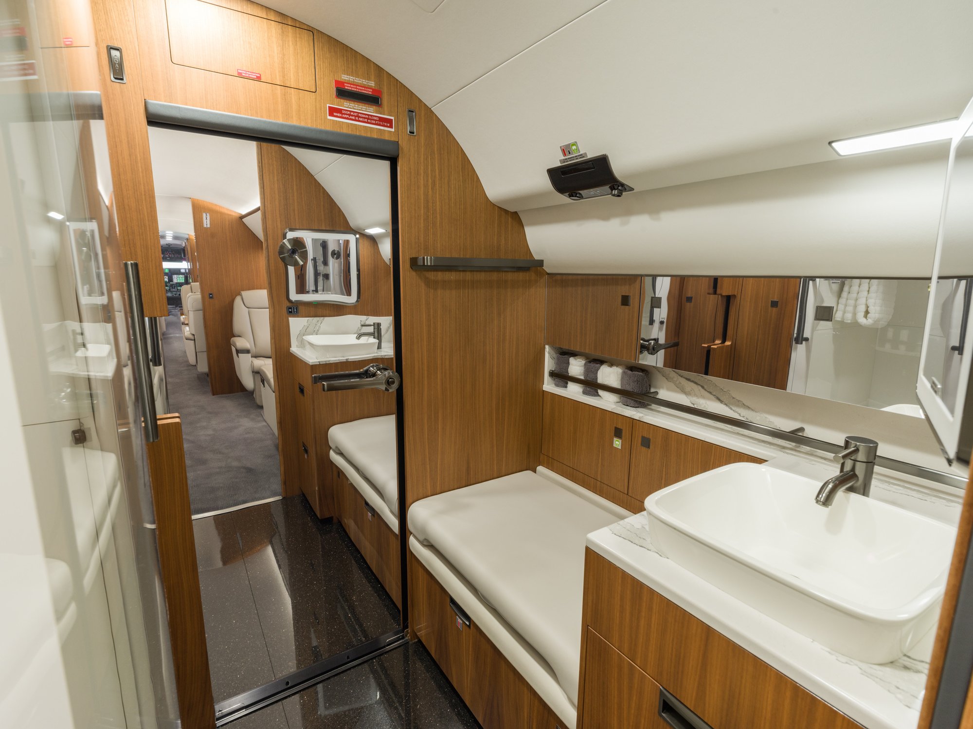 Aft lavatory of the Gulfstream 650ER viewed looking aft, highlighting its elegant design with premium fixtures and ample space, offering a refined in-flight experience.