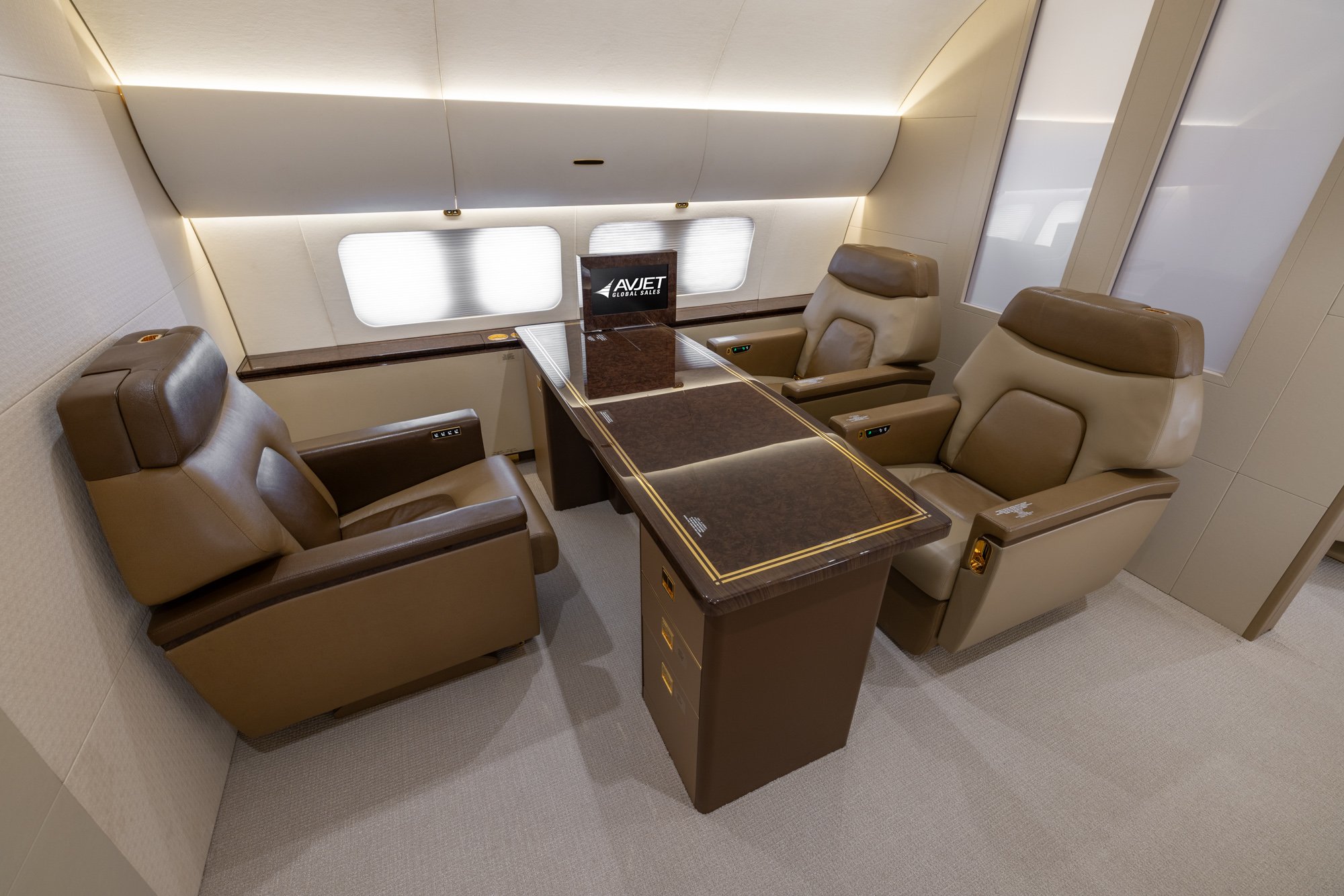 The forward view of the VIP Office highlights a refined executive workspace featuring a large display screen, a dedicated conference table, and oversized executive seating. Designed to mirror the functionality of a private office, this space provides an ideal setting for meetings, presentations, and productive work while in flight.