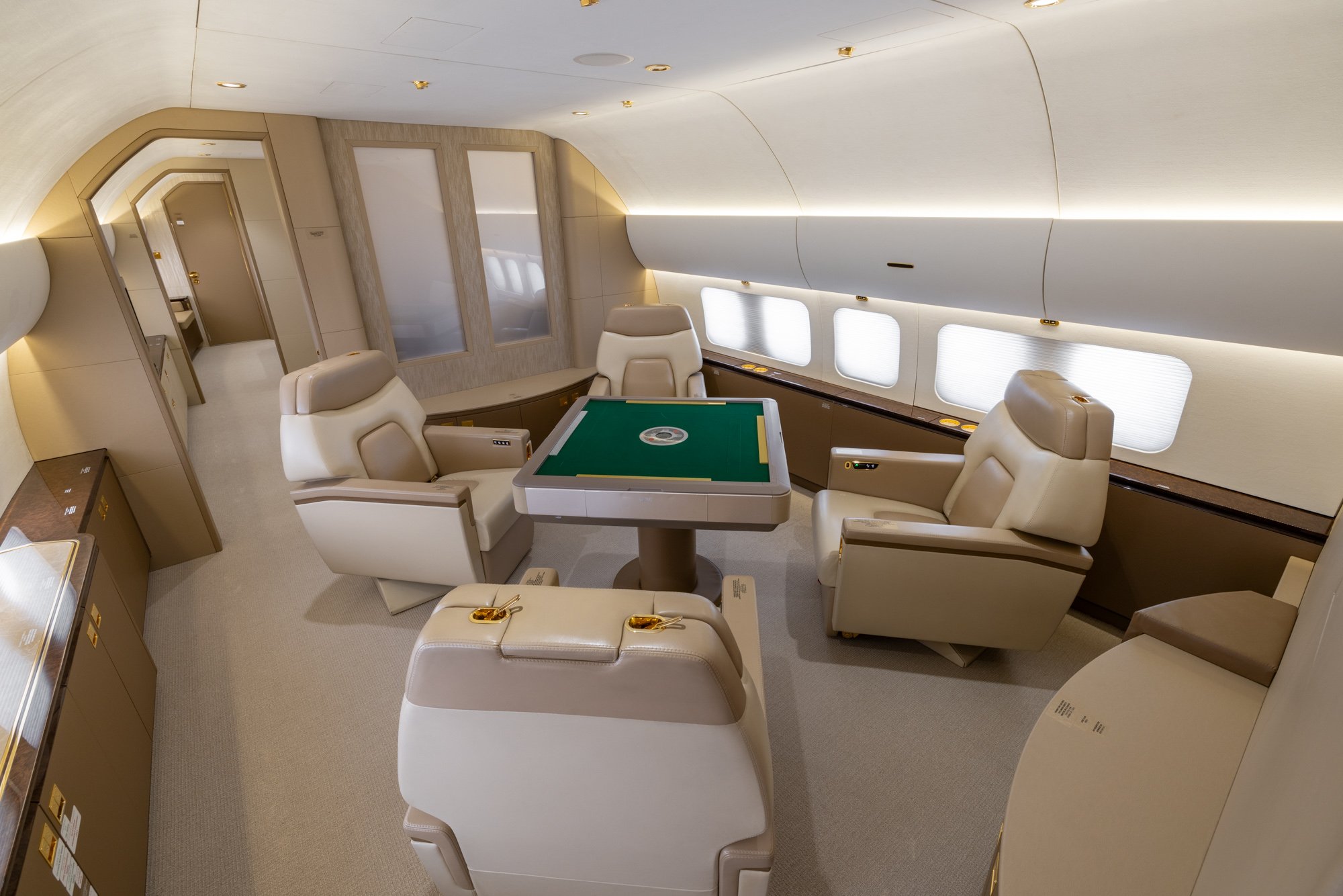 Meeting area with four executive seats and a custom mahjong table, offering a refined space for business meetings, games, and social interaction aboard the Boeing Business Jet 2 (BBJ2).