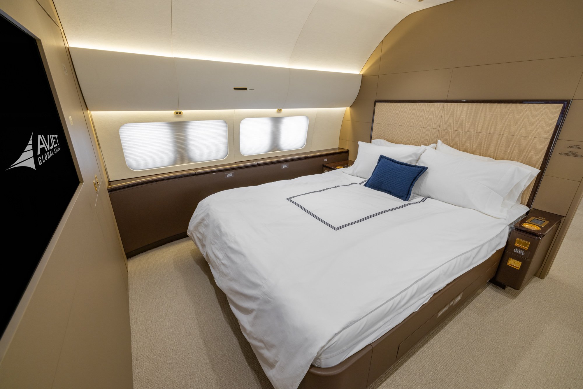 Forward view of the VIP Stateroom featuring a large bed, entertainment display, and elegant furnishings, creating a private and comfortable sleeping suite aboard the Boeing Business Jet 2 (BBJ2).