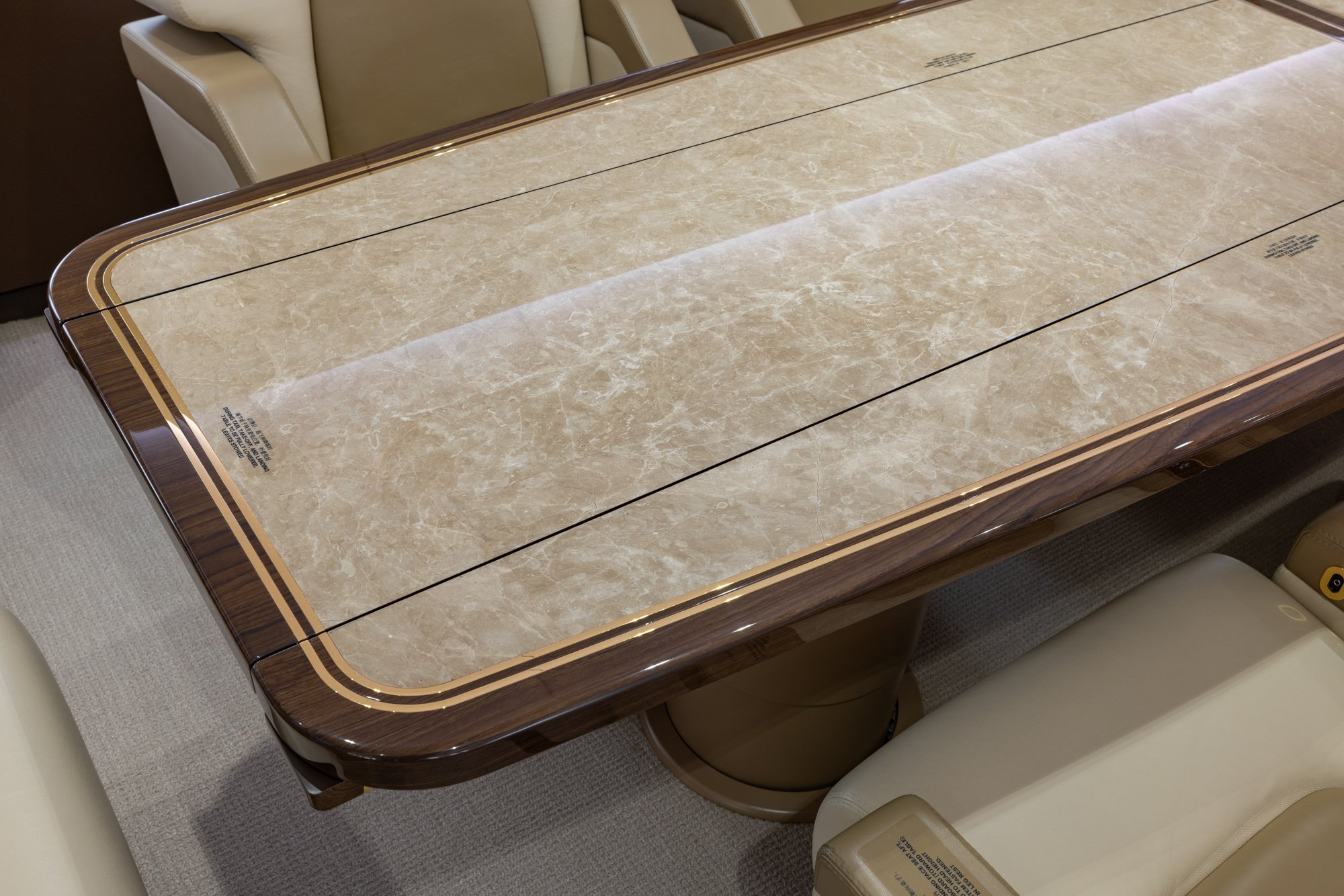 Large VIP dining table surrounded by executive seating, creating a spacious and elegant environment for meetings and fine dining aboard the Boeing Business Jet 2 (BBJ2).
