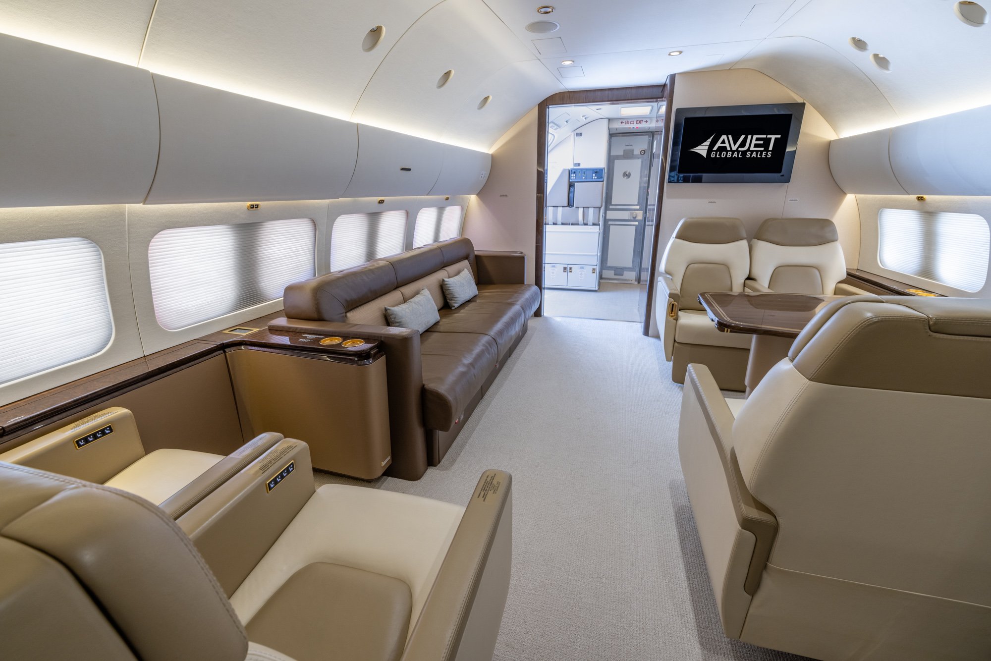 The Forward Lounge – Forward View of the 2018 Boeing Business Jet 2 (BBJ2) offers a spacious and inviting environment for relaxation and conversation. Featuring plush leather seating, elegant finishes, and a modern entertainment system, this luxurious lounge provides the perfect setting for passengers to unwind or socialize in complete comfort during flight.