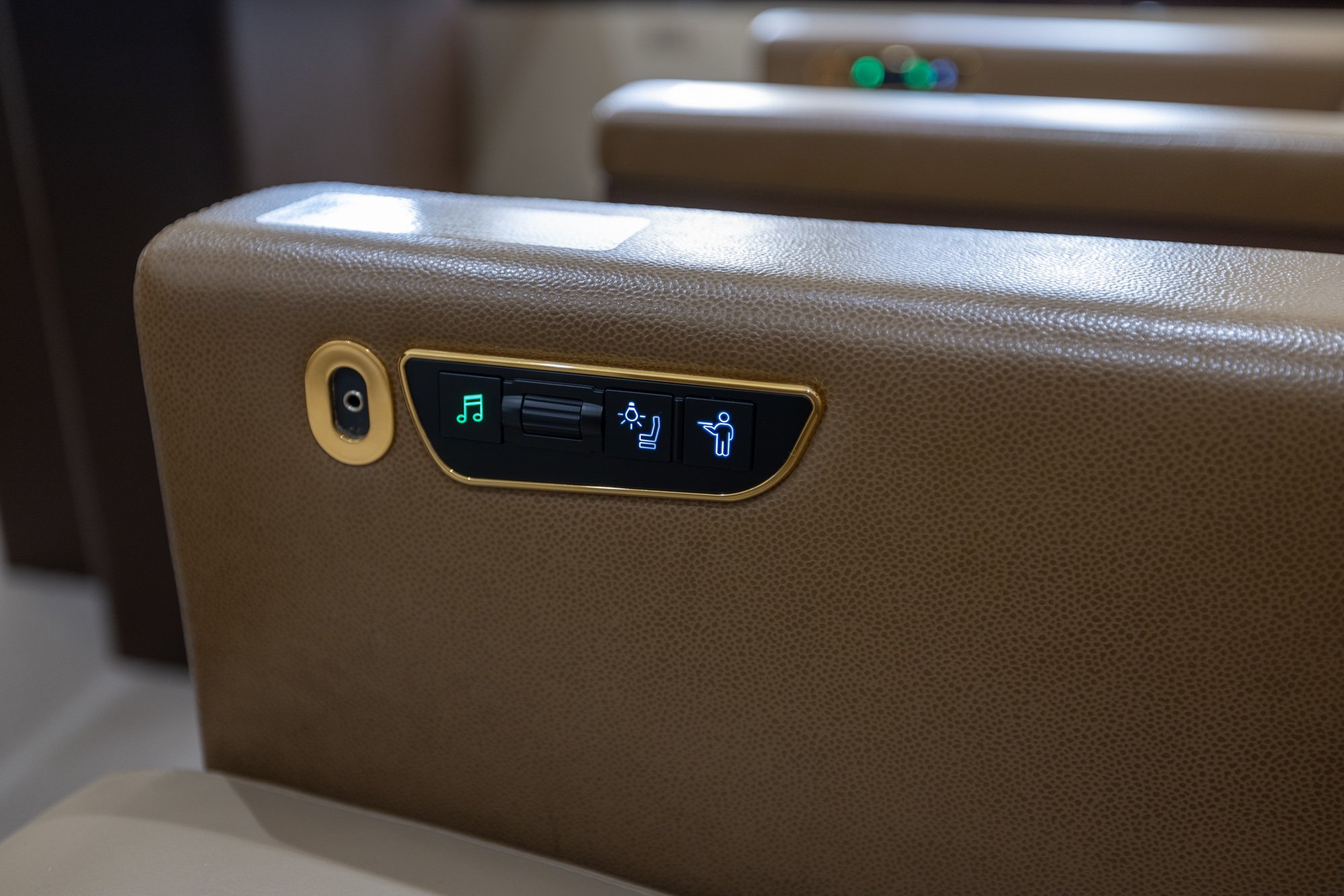 Integrated passenger control panel with digital cabin controls, headphone storage, entertainment functions, and service call buttons aboard the Boeing Business Jet 2 (BBJ2).