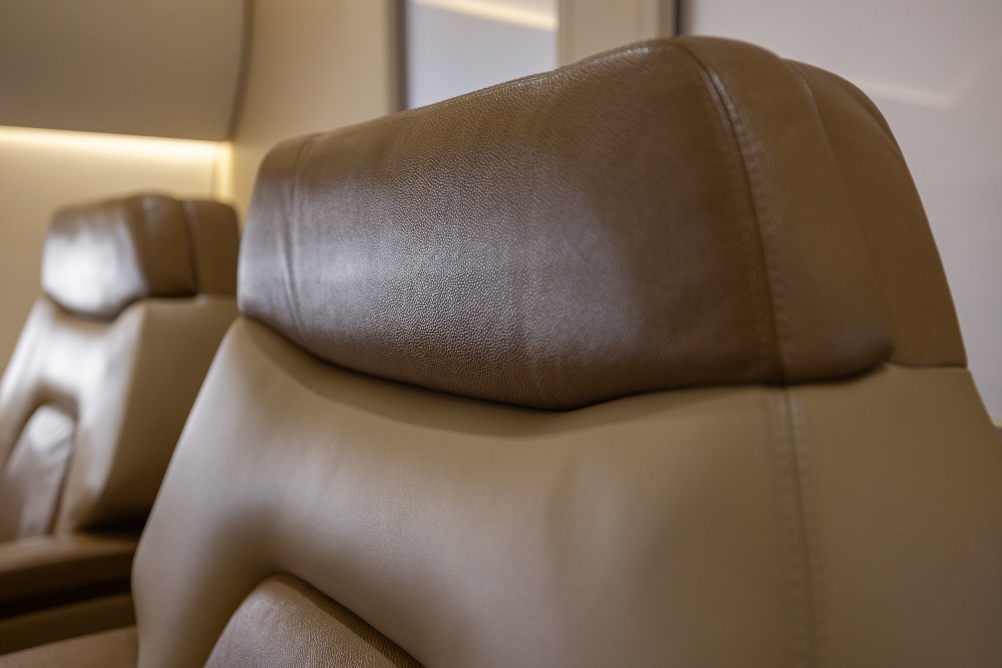 Exquisite materials and meticulous craftsmanship come together in this detailed view of the BBJ2 cabin, featuring supple leather seating, elegant wood finishes, and bespoke detailing that elevate the private aviation experience.