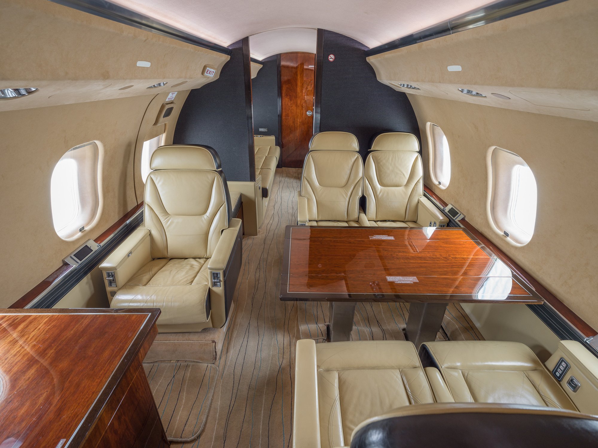 Mid-cabin view of the 2007 Bombardier Global XRS looking aft, showcasing the seamless transition to the spacious aft cabin with luxurious seating and refined finishes.