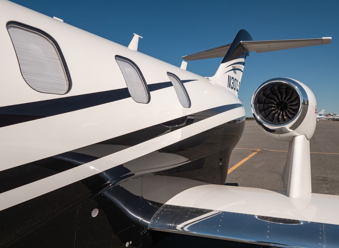 2022 HondaJet Elite S exterior detail showing the over-the-wing engine mount, sleek fuselage lines, tinted cabin windows, and aerodynamic wing design on the airport tarmac.