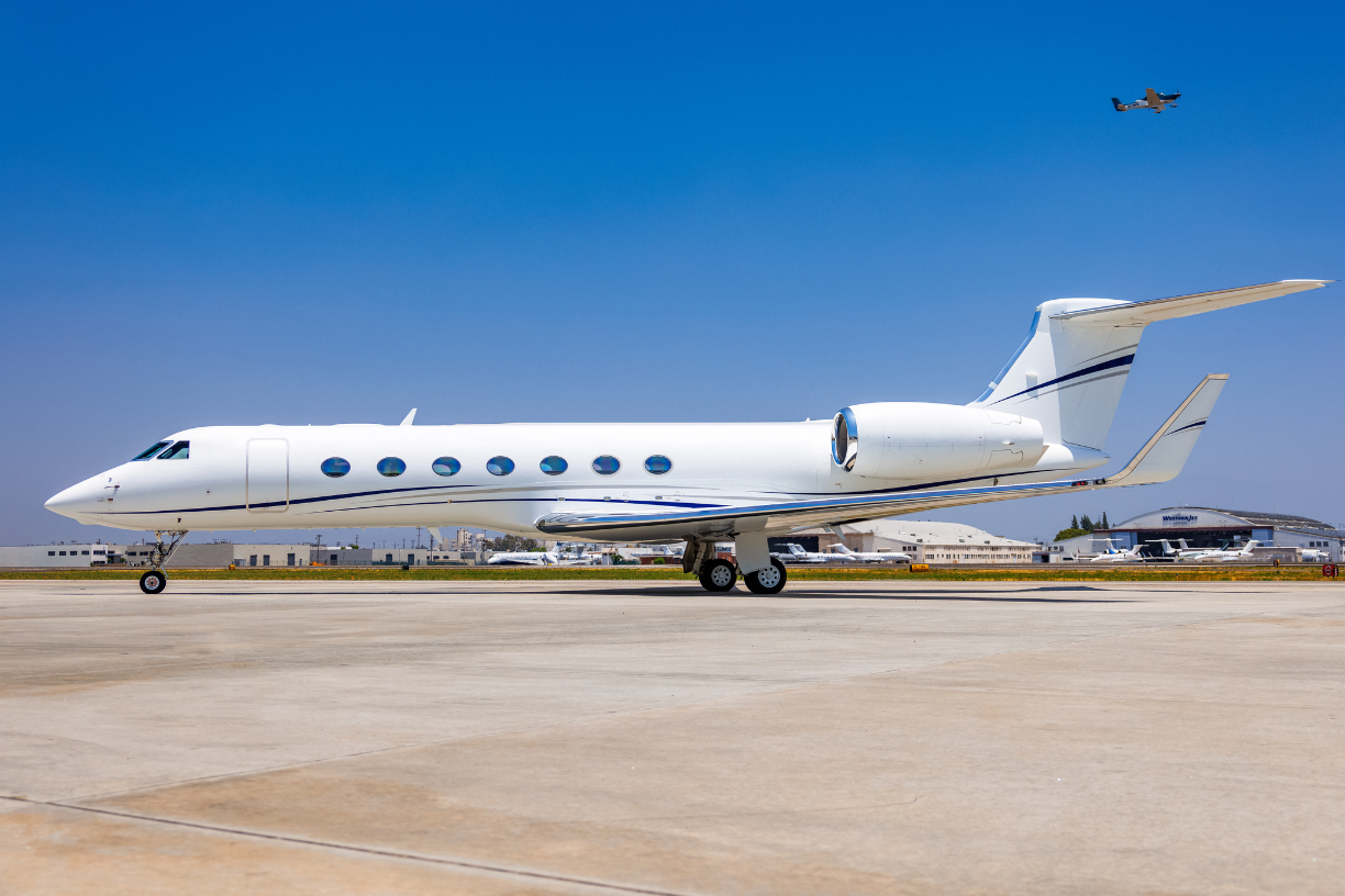 2016 Gulfstream G550, sleek white private jet with distinctive Gulfstream design, parked on runway.