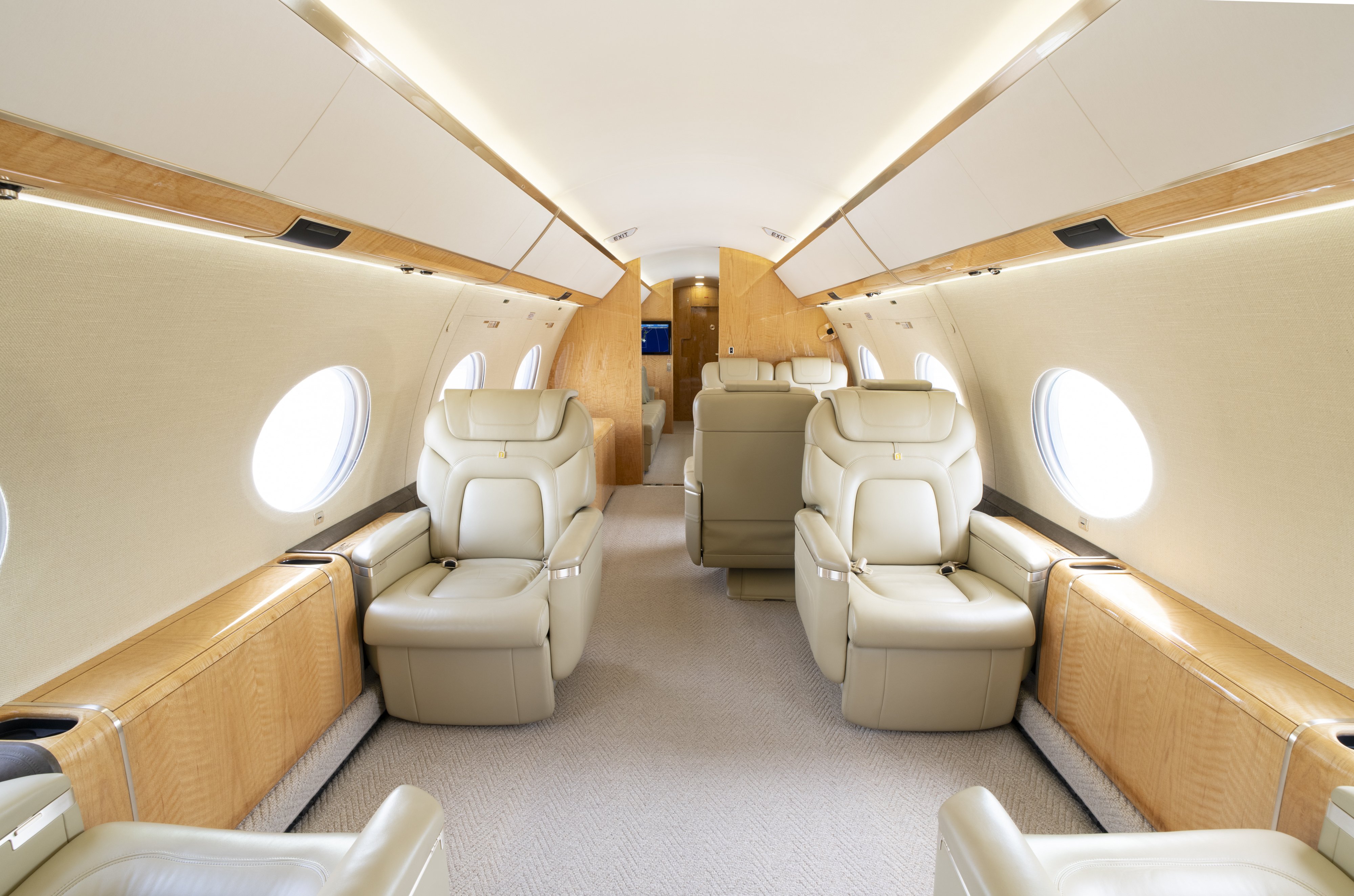 Elegant forward cabin of the 2014 Gulfstream G650ER with a four-place club seating arrangement and two-fold-out side ledge tables for meetings or leisure.